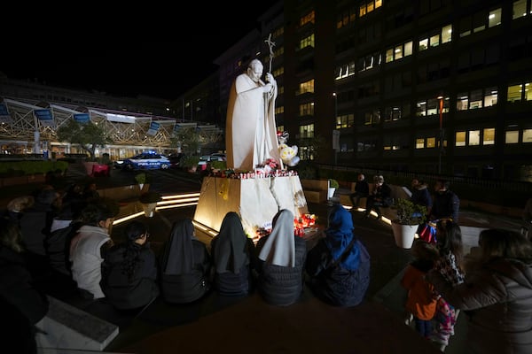 People pray for Pope Francis in front of the Agostino Gemelli Polyclinic, in Rome, Sunday, Feb. 23, 2025, where the Pontiff is hospitalized since Friday, Feb. 14. (AP Photo/Andrew Medichini)