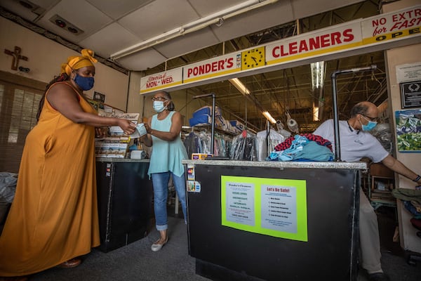 Ponder’s Cleaners owner Deborah Ponder (center) hands a receipt to a customer as her husband, Roderick Ponder, sorts clothing at their business in Atlanta, Saturday, June 13, 2020. (Photo: Branden Camp for The Atlanta Journal-Constitution)