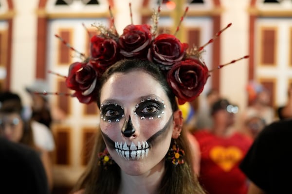 A reveler poses for a photo on a street during Carnival in Sao Luiz do Paraitinga, Brazil, Sunday, March 2, 2025. (AP Photo/Andre Penner)