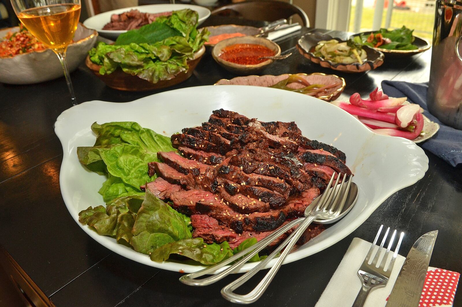 Cookbook author Seung Hee Lee makes this Grilled Korean-style Beef Barbecue on a charcoal grill, then presents it with slaw and condiments for making wraps. (Photo by Chris Hunt/Special; styling by Seung Hee Lee.)