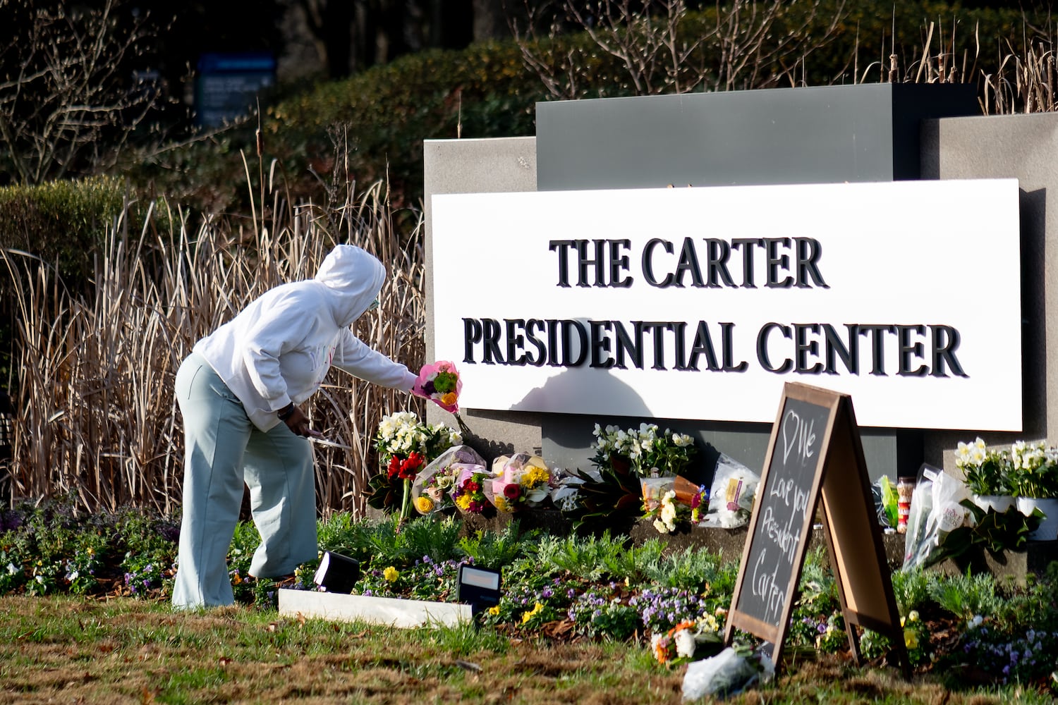 Flowers, candles and peanuts line the sign at The Carter Presidential Center in Atlanta,Georgia after the death of the former president.