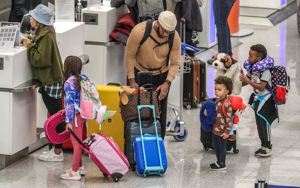 Andrea Boone (from left), Bradley Boone, Donald T. Boone, D.J. Boone and Noel Boone all from Atlanta prepare to depart from Terminal North at Hartsfield-Jackson. (John Spink/AJC 2023)

