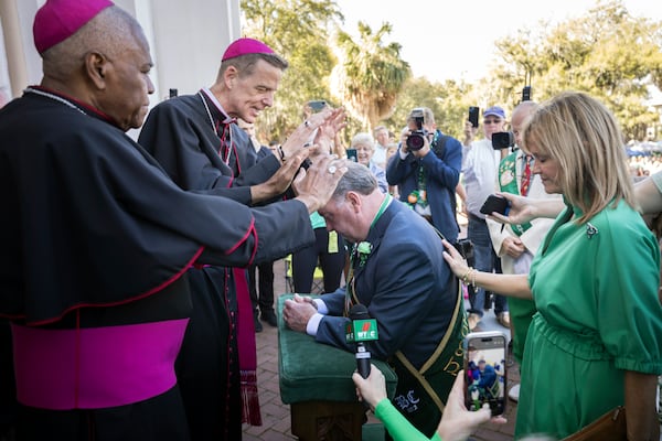 Catholic Bishop Stephen Parkes, center right, blesses John P. Forbes, center, the 2024 Grand Marshal of Savannah's historic St. Patrick's Day parade on March 16, 2024, in Savannah, Ga. It was the 200th parade in Savannah since the first one in 1824. (AJC Photo/Stephen B. Morton)