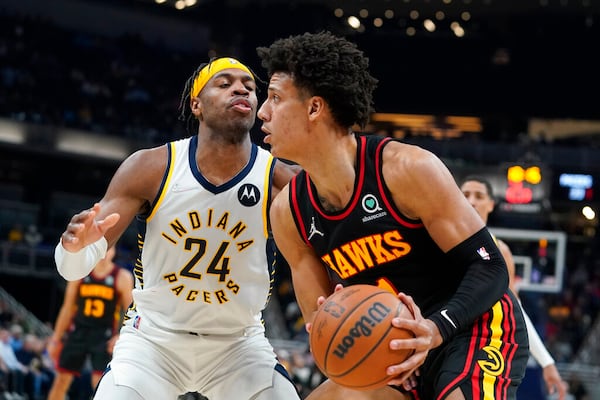 Atlanta Hawks' Jalen Johnson, right, looks to shoot against Indiana Pacers' Buddy Hield (24) during the first half of an NBA basketball game, Monday, March 28, 2022, in Indianapolis. (AP Photo/Darron Cummings)