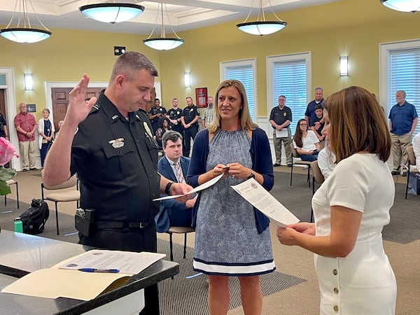 Snellville Mayor Barbara Bender (R) administers the oath of office for Police Chief Greg Perry with his wife, Katie, by his side on Monday, June 28, 2021. (Tyler Wilkins / tyler.wilkins@ajc.com)