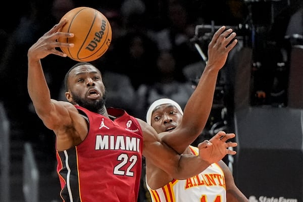 Miami Heat forward Andrew Wiggins (22) tries to shoots against Atlanta Hawks guard Terance Mann (14) during the first half of an NBA basketball game, Monday, Feb. 24, 2025, in Atlanta. (AP Photo/Mike Stewart)