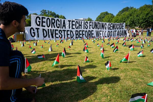 A first-year student places flags around a memorial on the Georgia Tech campus green in honor of the Palestinian victims who have lost their lives in the Israel-Hamas war. Olivia Bowdoin for the Atlanta Journal-Constitution