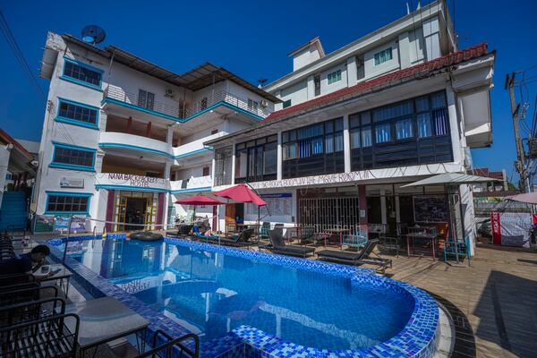 A foreign tourist couple rest near a swimming pool at Nana Backpackers hostel in Vang Vieng, Laos, Friday, Nov. 22, 2024. (AP Photo/Anupam Nath)