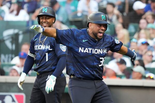 National League's Elias Díaz, of the Colorado Rockies, celebrates his two run home run with Ozzie Albies, of the Atlanta Braves, in the eighth inning during the MLB All-Star baseball game in Seattle, Tuesday, July 11, 2023. (AP Photo/Ted S. Warren)