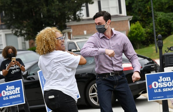 U.S. Senate candidate Jon Ossoff and Jo Handy-Sewell, president of DeKalb Democratic Women, share an elbow bump greeting as he arrives for a yard-sign pickup event on Saturday, September 26, 2020. Hyosub Shin / Hyosub.Shin@ajc.com)