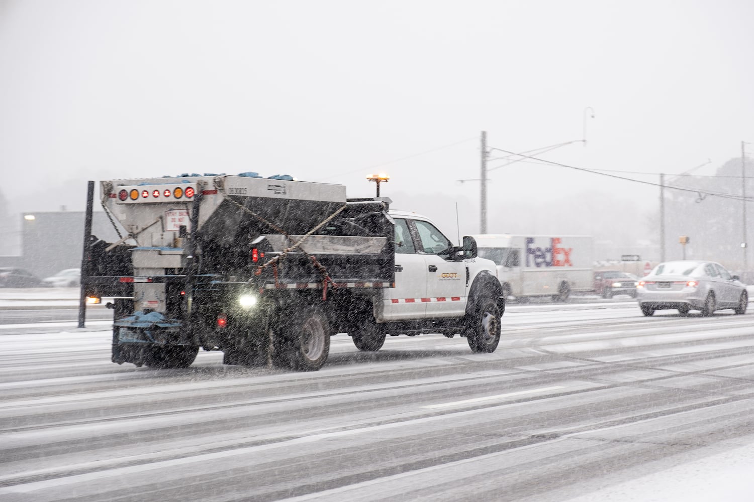 A salt truck makes its way down Lawrenceville Highway in Decatur as snow begins to cover the road Tuesday, Jan. 21, 2025. (Ben Gray for the Atlanta Journal-Constitution)