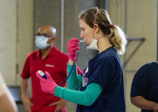 CVS nurse Evelyn Larson goes through the steps to check-in in preparation for the opening of the COVID-19 drive-through testing center in Atlanta, April 6, 2020.  STEVE SCHAEFER / SPECIAL TO THE AJC