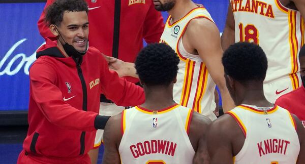 Atlanta Hawks guard Trae Young, left, celebrates a win with teammates Brandon Goodwin (0) and Nathan Knight (1) at the end of an NBA basketball game against the Orlando Magic Thursday, May 13, 2021 in Atlanta. (AP Photo/Tami Chappel)