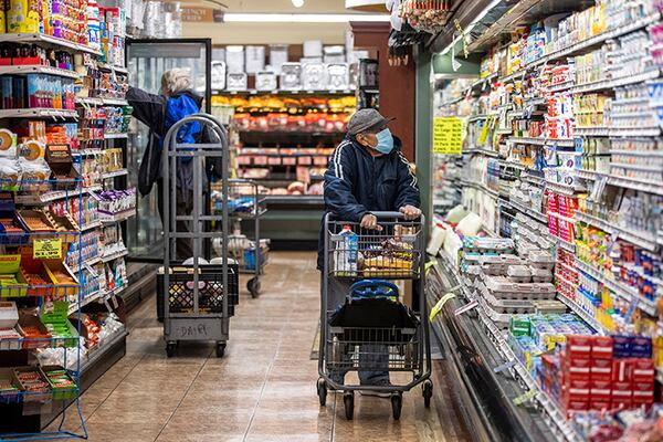 Shoppers wear face masks at Key Food grocery store in New York. Some grocery workers have expressed concern about shoppers making them sick. The spread of the virus through the food and grocery industry is expected to cause disruptions in production and distribution of certain staples like pork and chicken, industry executives, labor unions and analysts have warned in recent days.