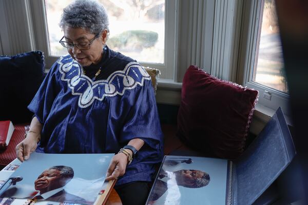 Photographer Susan “Sue” Ross looks at her photos of Nelson Mandela at Hammond’s House Museum on Friday, Feb. 2, 2024. (Natrice Miller/ Natrice.miller@ajc.com)