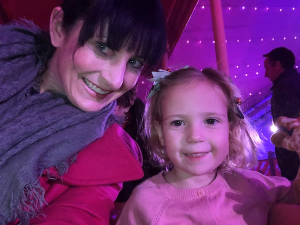 Richeal Bair rides the Pink Pig with one of her daughters, Keira, at Lenox Square in 2018. That would be the pig's second-to-last year. (Courtesy of Richeal Bair)