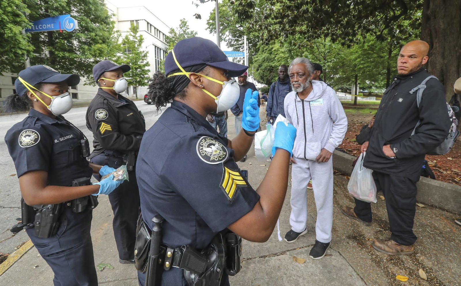 In an April 2020 file photo, Atlanta police officer Brittany Searight, Sgt. Sabrina Smith and Sgt. Dominique Simmons distribute masks at Hurt Park in downtown Atlanta. JOHN SPINK/SPINK@AJC.COM