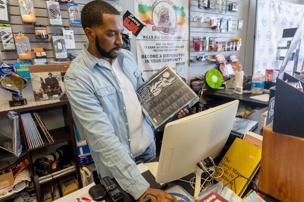 DBS Sounds store manager Darnel “Mooch” Howell looks up information for a customer at his Riverdale store  Tuesday, Dec. 19, 2023.  (Steve Schaefer/steve.schaefer@ajc.com)