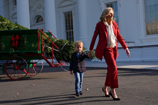 First lady Jill Biden, right, walks with her grandson Beau Biden after receiving the official 2024 White House Christmas Tree on the North Portico of the White House in Washington, Monday, Nov. 25, 2024. Cartner's Christmas Tree Farm from Newland, N.C., provided the Fraser fir that will be displayed in the Blue Room of the White House. (AP Photo/Susan Walsh)