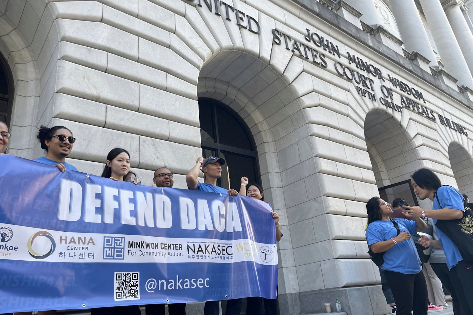 Demonstrators supporting Biden Administration efforts to protect immigrants brought to the U.S. illegally when they were children hold signs in front of the federal appeals court in New Orleans on Thursday, Oct 19, 2924. (AP Photo/Kevin McGill)