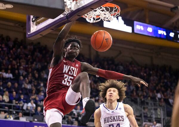 Washington State forward Mouhamed Gueye dunks against Washington center Braxton Meah during the second half of an NCAA college basketball game Thursday, March 2, 2023, in Seattle. (AP Photo/Stephen Brashear)