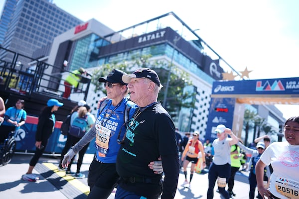 Cliff Housego, center, is hugged by Nancy la Scala after he finished the LA Marathon Sunday, March 16, 2025, in Los Angeles. (AP Photo/Eric Thayer)