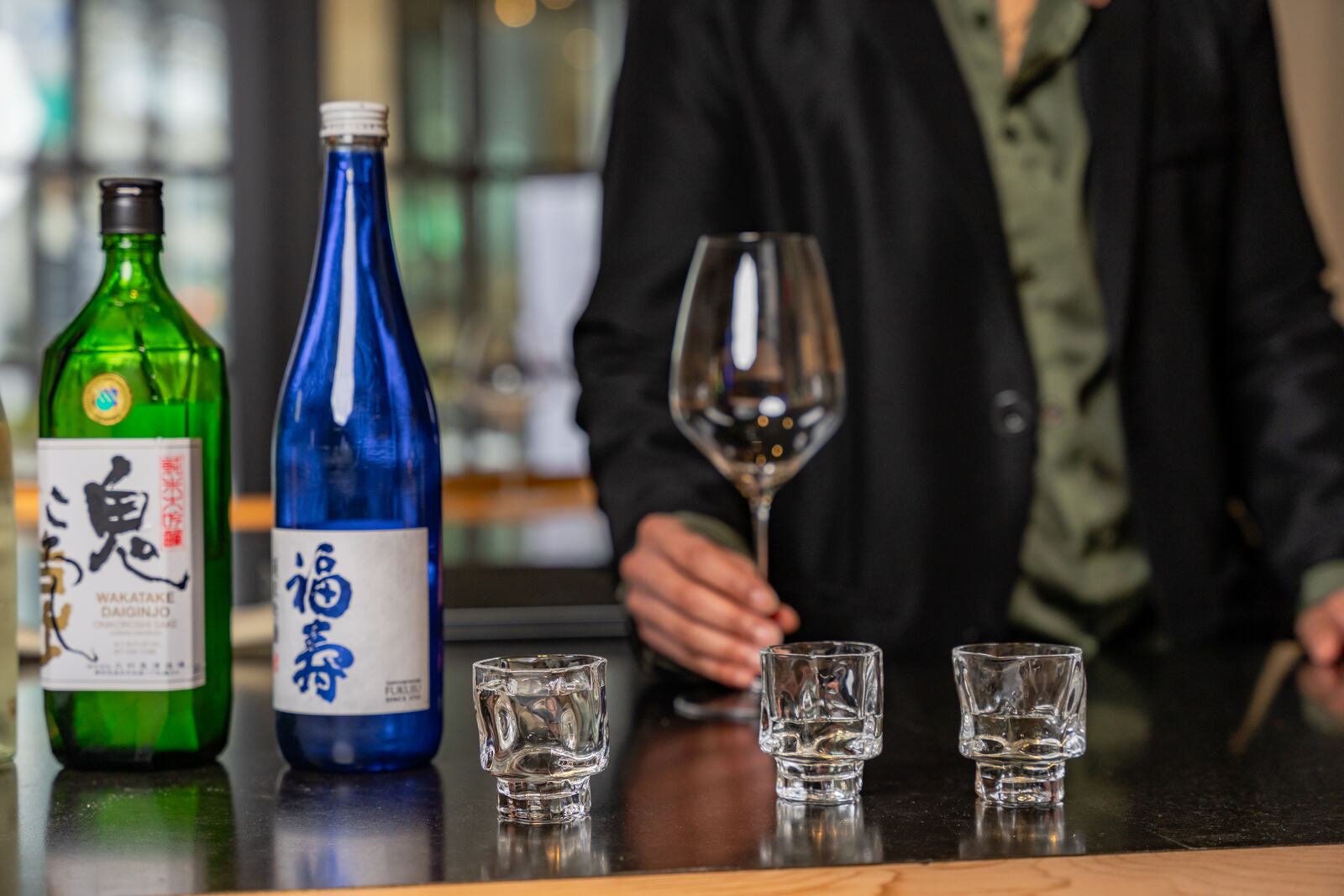 Glasses on display next to some of Mona Allen’s favorite sakes at Brush Sushi. Allen says that she fell in love with the drink after being elevated to Brush’s beverage director. (Jason Allen/Atlanta Journal-Constitution) 