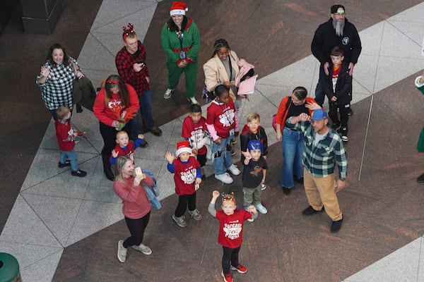 Boys and girls wave as they disembark from the train on their way to the United Airlines annual "fantasy flight" to a fictional North Pole at Denver International Airport, Saturday, Dec. 14, 2024, in Denver. (AP Photo/David Zalubowski)