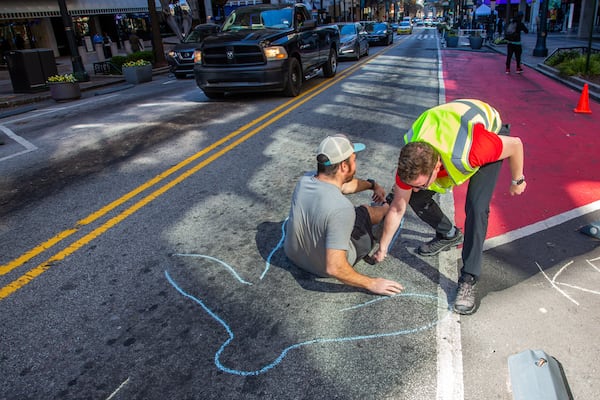 Protesters draw a chalk outline of a body along Peachtree St., NE Monday, March 14, 2022. STEVE SCHAEFER FOR THE ATLANTA JOURNAL-CONSTITUTION