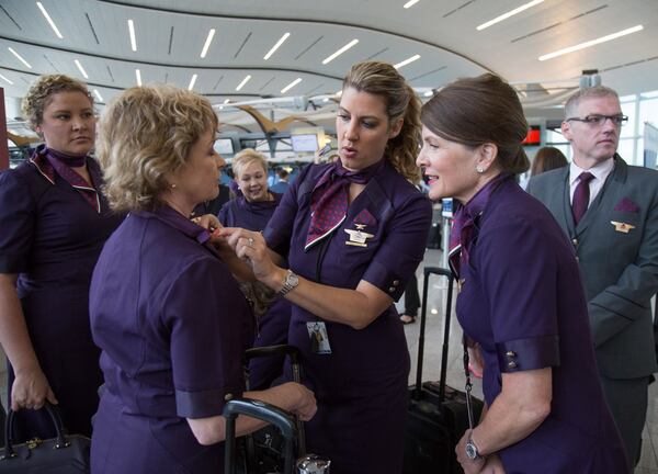 Erica Stewart (center) helps Freda Sims (left) made sure her new uniform is looking good, while Carol Stockdale (right) looks on, before the start of the Delta Uniform launch at the International Terminal lobby in Atlanta GA Tuesday, May 29, 2018. STEVE SCHAEFER / SPECIAL TO THE AJC