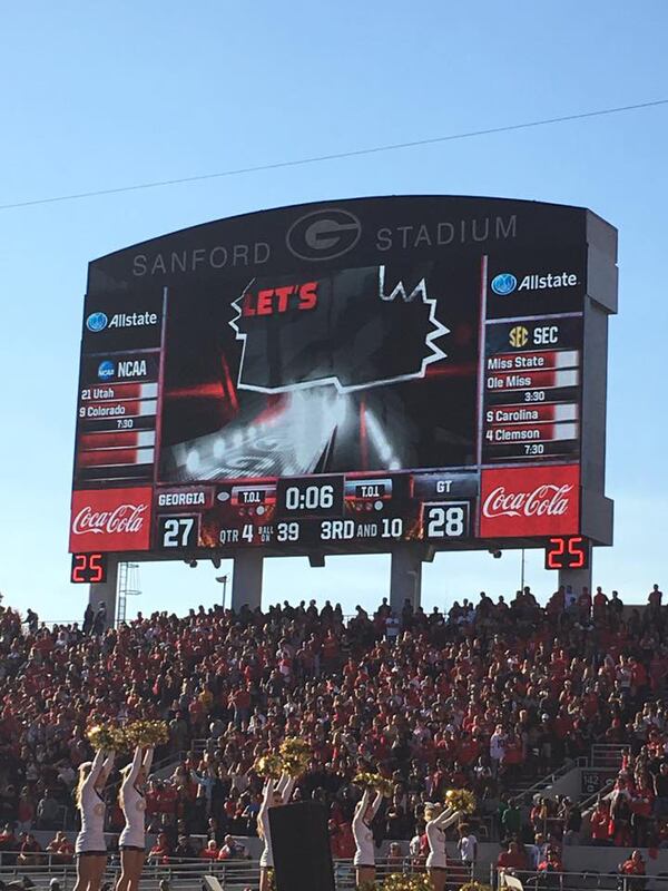 Georgia Tech cheerleaders lead the crowd in a cheer as the final seconds tick off on the Sanford Stadium scoreboard in the Yellow Jackets' win Saturday in Athens.