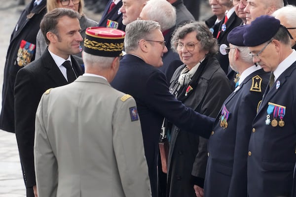 French President Emmanuel Macron, left, and British Prime Minister Keir Starmer, center, meet veterans during ceremonies marking the 106th anniversary of the Armistice, a celebration of their countries' friendship, as nations across the world pay tribute to their fallen soldiers in World War I, Monday, Nov. 11, 2024 in Paris, (AP Photo/Michel Euler, Pool)