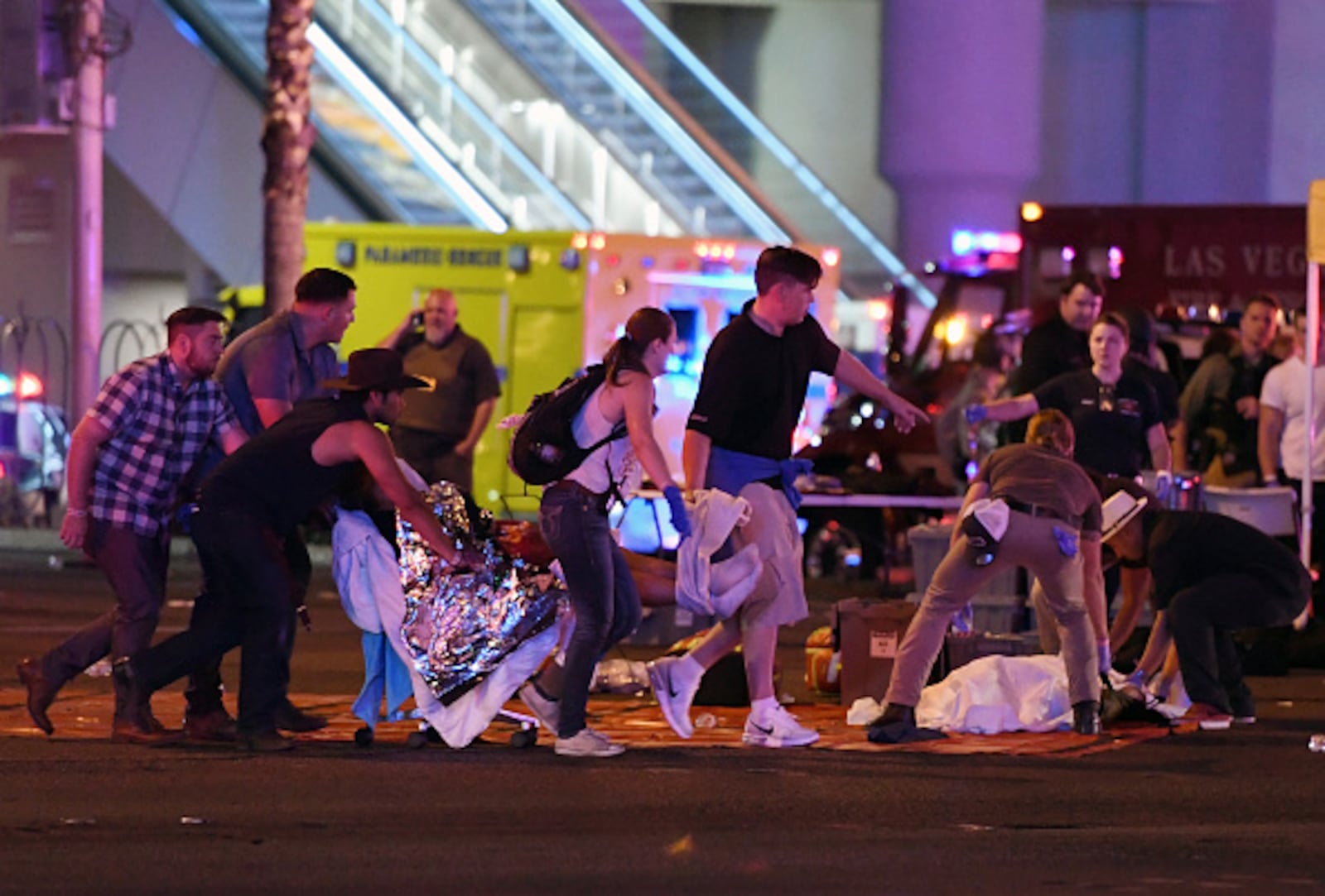 An injured person is tended to in the intersection of Tropicana Ave. and Las Vegas Boulevard after a mass shooting at a country music festival nearby on October 2, 2017 in Las Vegas, Nevada. A gunman opened fire on the music festival killing over 50 people. (Photo by Ethan Miller/Getty Images)