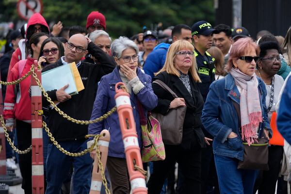 People stand outside the U.S. embassy in Bogota, Colombia, Monday, Jan. 27, 2025, where they were notified their visa appointments were canceled due to Colombian President Gustavo Petro's refusal to accept repatriation flights of Colombian citizens from the United States. (AP Photo/Fernando Vergara)