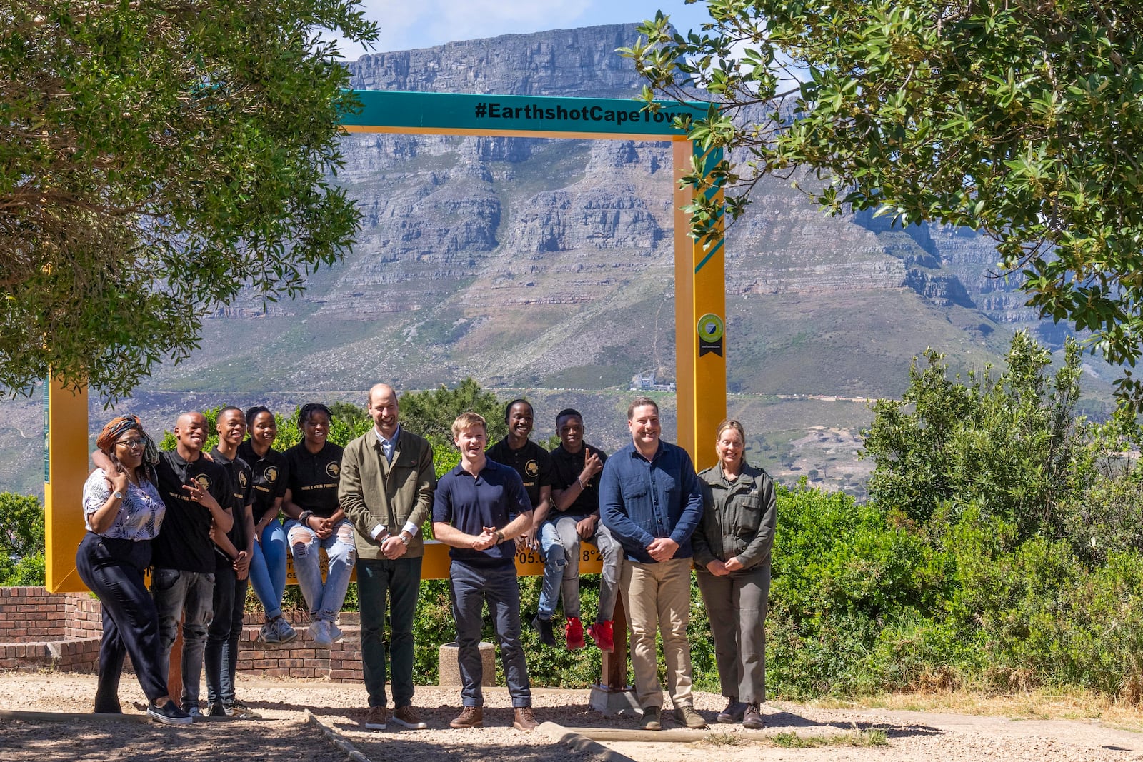 Britain's Prince William, center, poses for a group photo with Park Manager for Table Mountain National Park Megan Taplin, right, and Australian conservationist and Earthshot Prize global ambassador Robert Irwin, center right, and a group of youth volunteers in Cape Town, South Africa, Tuesday, Nov. 5, 2024. (AP Photo/Jerome Delay, Pool)