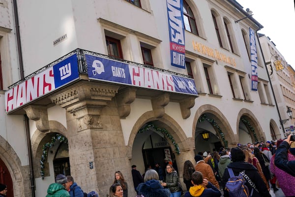 New York Giants supporters queue outside the traditional 'Hofbraeuhaus' in Munich, Germany, Saturday, Nov. 9, 2024 ahead of the NFL match between the Carolina Panthers and the New York Giants in Munich on Sunday. (AP Photo/Matthias Schrader)