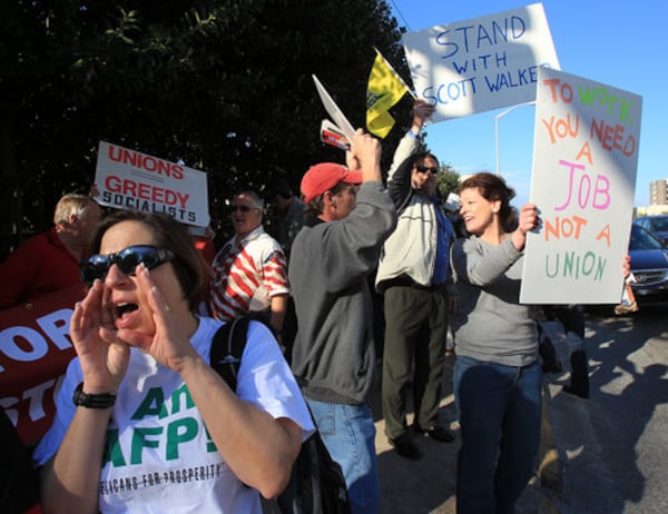 Betsy Shaw Kramer, left, of Johns Creek, a Georgia Tea Party Patriots and Americans for Prosperity member, tries to get the union supporters' attention.