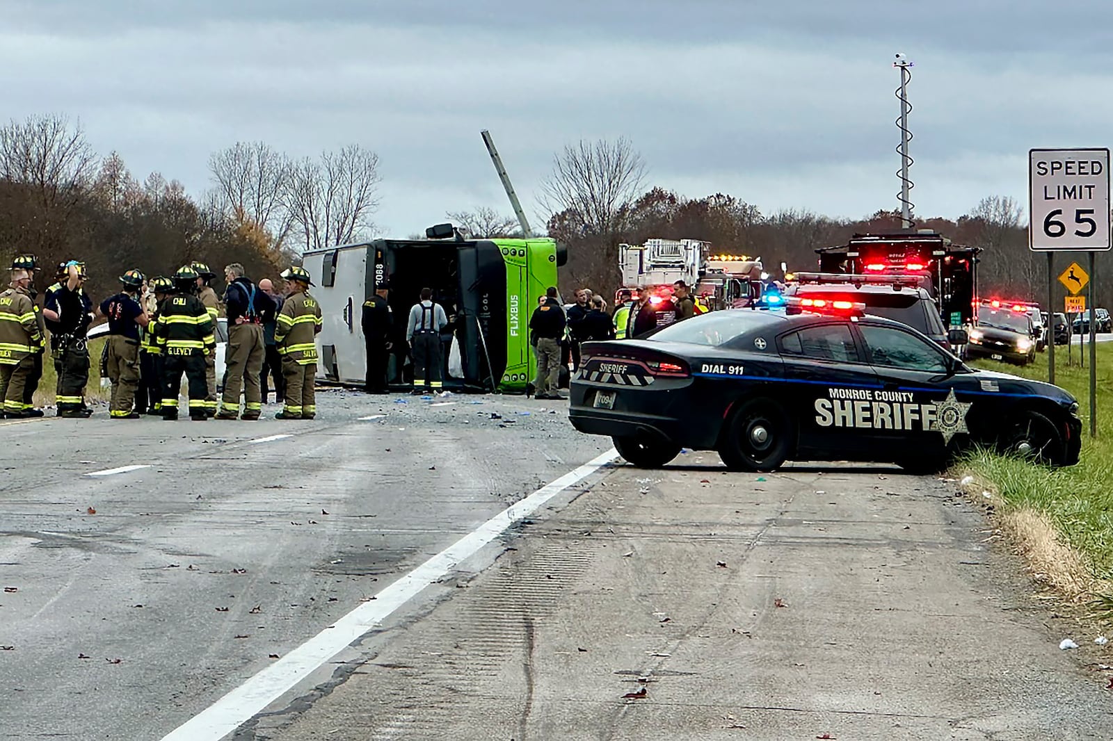 First responders investigate the scene where a tour bus rolled over on westbound Interstate 490 critically injuring one and sending all 28 passengers to area hospitals, Thursday, Nov. 7, 2024, in Chili, N.Y. (Monroe County Sheriff's Office via AP)