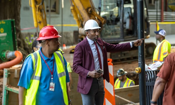 Atlanta Mayor Andre Dickens (center) visits West Peachtree Street and 11th Street in Midtown on Tuesday, June 4, 2024, where repairs are ongoing to fix a broken main on the fifth day of the water crisis. (John Spink/AJC)