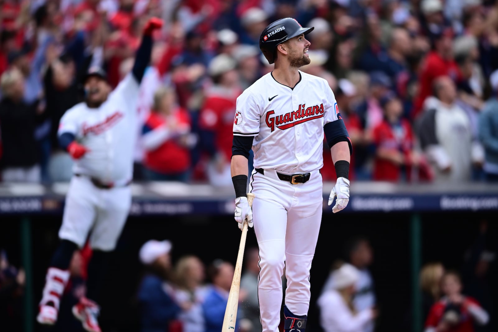 Cleveland Guardians' Lane Thomas, right, watches his grand slam in the fifth inning during Game 5 of baseball's American League Division Series against the Detroit Tigers, Saturday, Oct. 12, 2024, in Cleveland. (AP Photo/David Dermer)