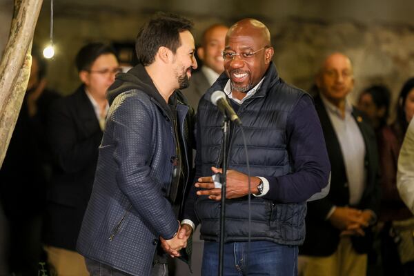 Lin-Manuel Miranda and U.S. Sen. Raphael Warnock embrace at Warnock’s Latino Early Vote Rally in Atlanta on Oct. 19, 2022.  (Arvin Temkar/AJC)