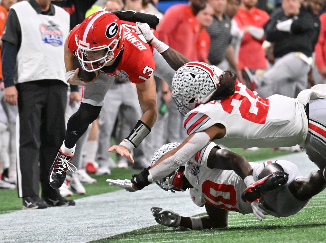 Georgia Bulldogs quarterback Stetson Bennett (13) goes airborne during a first quarter scramble. (Hyosub Shin / Hyosub.Shin@ajc.com)