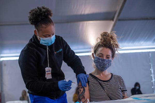 03/15/2021 —Doraville, Georgia — Atlanta resident Bethany Baer, 34, receives a COVID-19 vaccine shot from Nurse Devin Adkins at a DeKalb Board of Health COVID-19 vaccination site located at the Doraville MARTA transit station in Doraville, Monday, March 15, 2021. (Alyssa Pointer / Alyssa.Pointer@ajc.com)