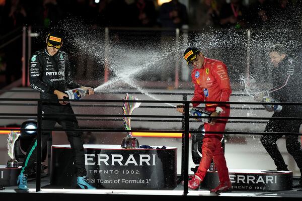 Mercedes driver George Russell, of Britain, left, sprays champagne on Ferrari driver Carlos Sainz, of Spain, after the F1 Las Vegas Grand Prix auto race, Saturday, Nov. 23, 2024, in Las Vegas.(AP Photo/Rick Scuteri)