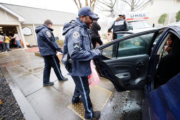 Community affairs officer Fed Joseph assisted a resident in getting to her car at Bradford Gwinnett apartment complex during a community outreach event on Thursday, Feb 2, 2023. Miguel Martinez / miguel.martinezjimenez@ajc.com