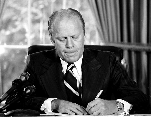 President Gerald Ford signs a document granting former President Richard M. Nixon "a full, free and absolute pardon" for all "offenses against the United States" during the period of his presidency in this Sept. 8, 1974 file photo in his White House office.    (AP Photo/File)