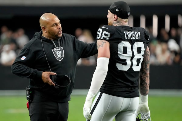 Las Vegas Raiders Head Coach Antonio Pierce talks with defensive end Maxx Crosby (98) during the first half of an NFL football game against the Denver Broncos, Sunday, Nov. 24, 2024, in Las Vegas. (AP Photo/Rick Scuteri)