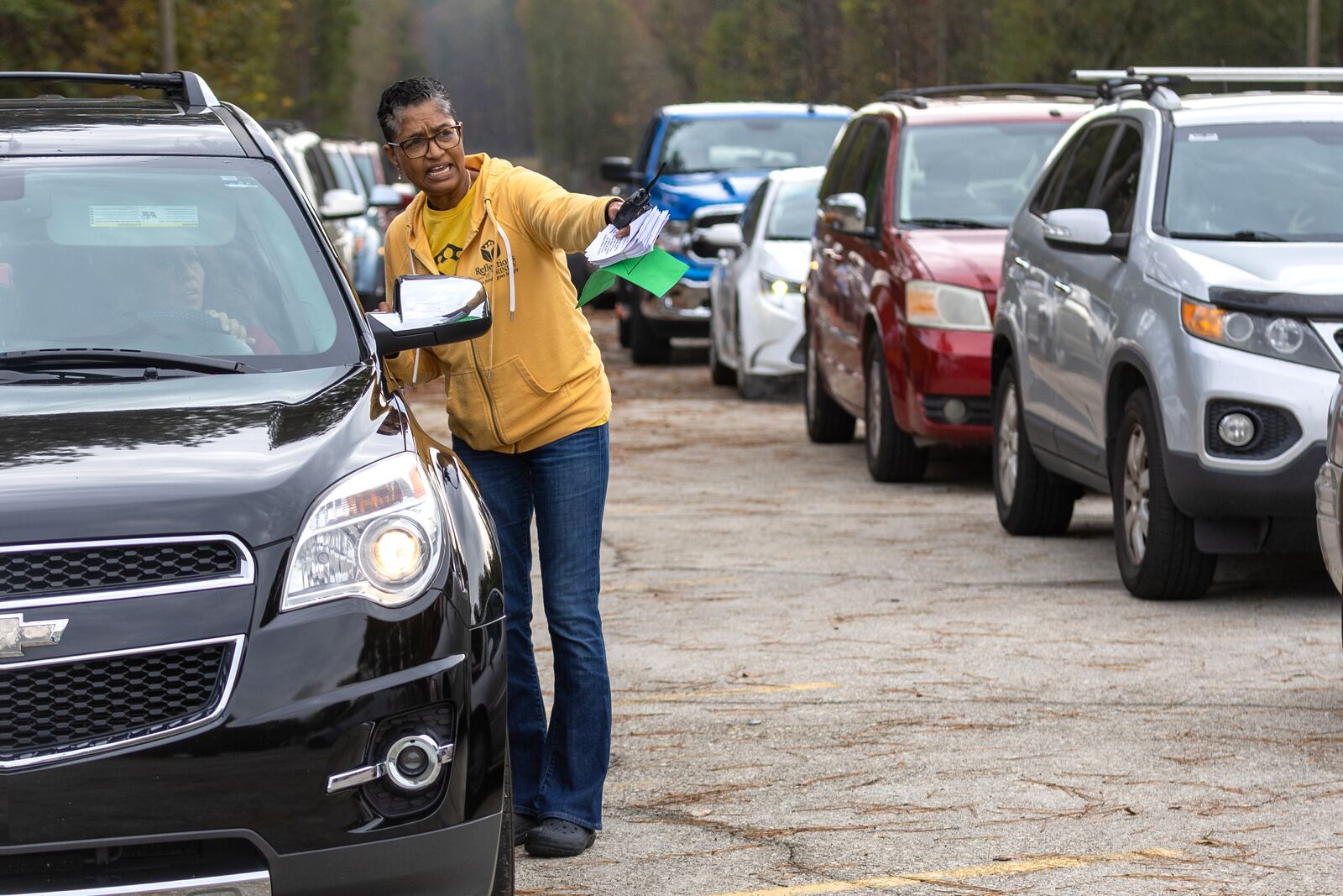 Laurie Wong directs traffic during the Reflections of Trinity weekly food distribution in Powder Springs on Saturday, Nov. 12, 2022. (Photo: Steve Schaefer / steve.schaefer@ajc.com)