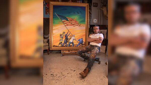 Artist Scott LoBaido poses next to his print, “Sunrise: A Tribute to First Responders.”