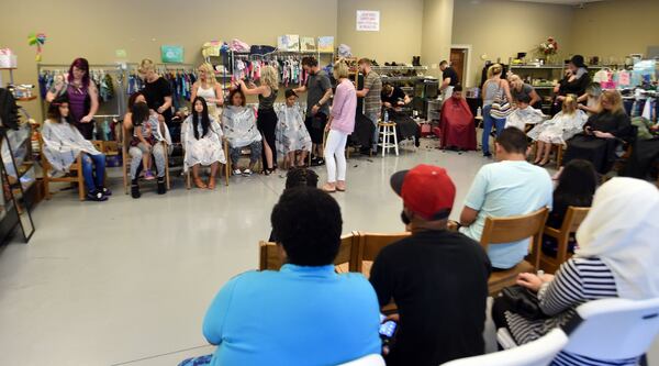 Matthew Miller, of Matthew’s & Co. Salon in Flowery Branch, brought 22 local stylists and assistants to give more than 100 haircuts on Monday to help kids get ready for school. The free haircuts were in partnership with North Gwinnett Co-op, which helps families in need. KENT D. JOHNSON / KDJOHNSON@AJC.COM